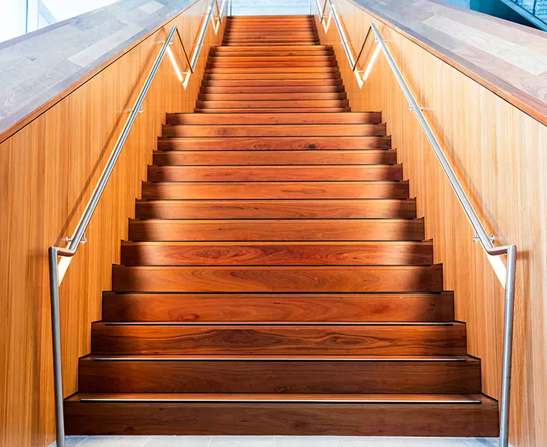drewniane schody z metalowymi poręczami